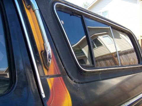 1979 Ford Bronco - Close-up of a 1979 Ford Bronco's side window, showing chrome trim and a partial flame graphic.