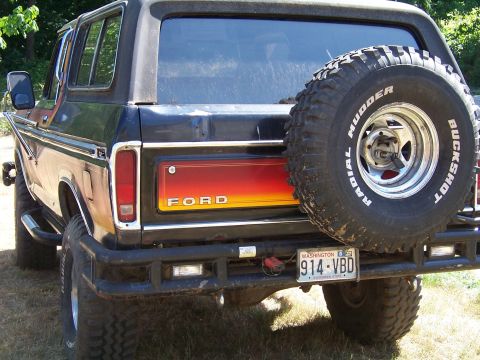 1979 Ford Bronco - Rear view of a 1979 Ford Bronco, a spare tire and a distinctive red and yellow tailgate panel.