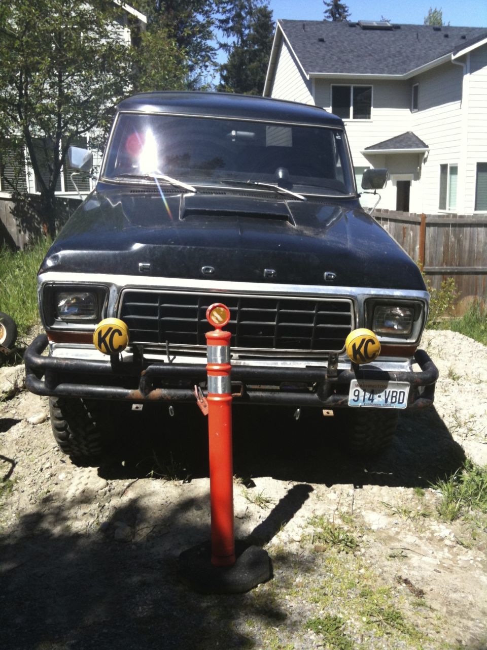Black 1978 Ford Bronco front view with KC lights and a license plate reading 914-VBD