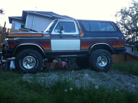 1979 Ford Bronco - This lifted Ford Bronco features a distinctive tri-color gradient paint scheme on its side panels.