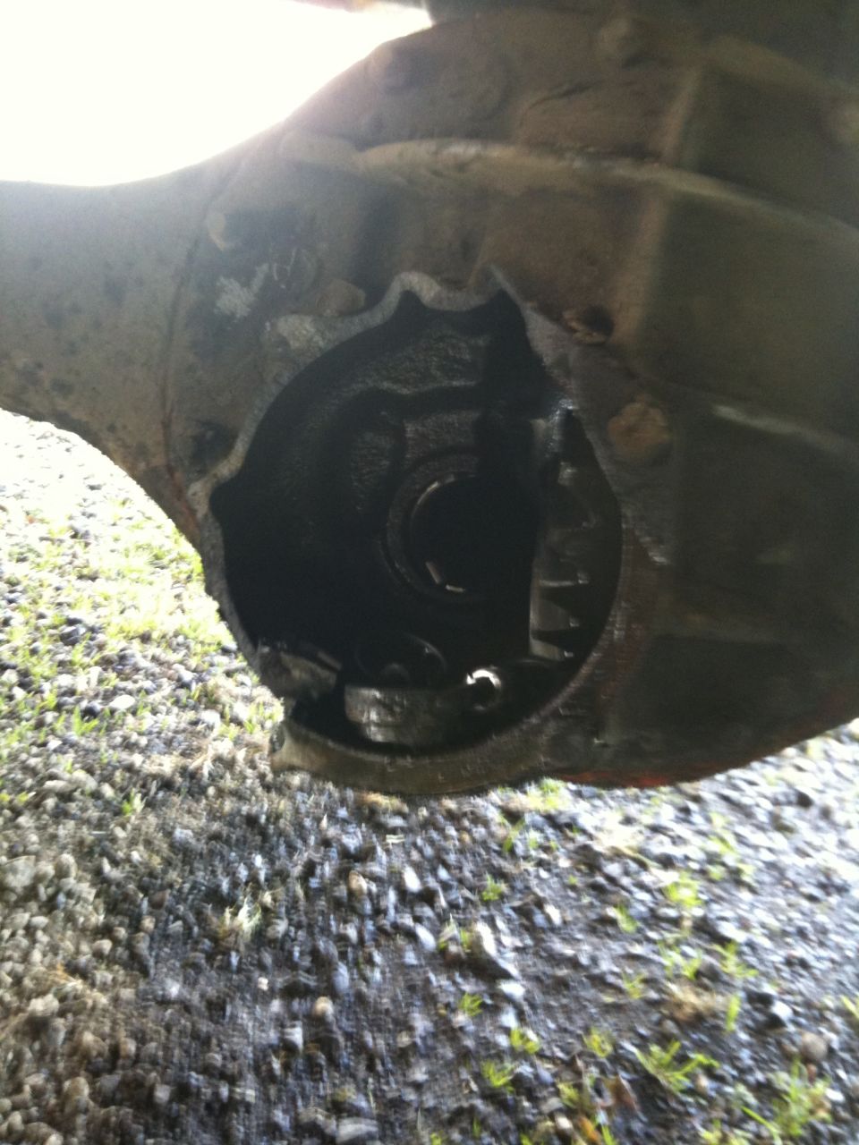 close-up of a damaged differential housing with gears visible inside