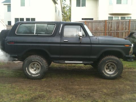 1979 Ford Bronco - Side profile of a black Ford Bronco, showing its body style and spare tire.