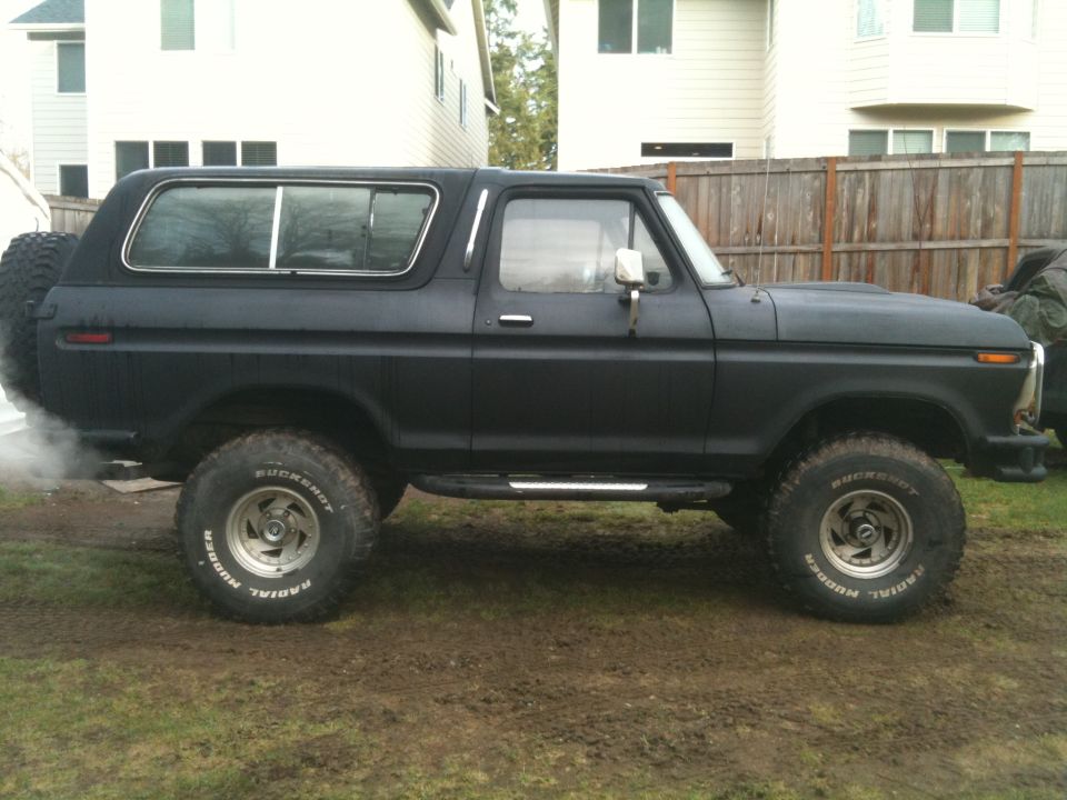 Black Ford Bronco, side view. Spare tire mounted on the rear