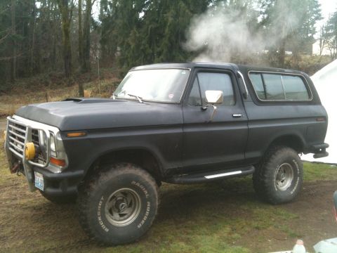 1979 Ford Bronco - This lifted black Ford Bronco is emitting a large cloud of smoke from its roof.