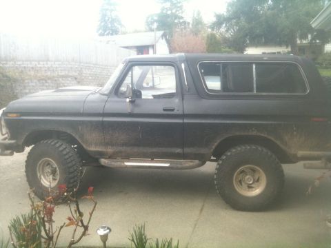 1979 Ford Bronco - A side view of a black 1978 Ford Bronco, showing its off-road modifications and condition.