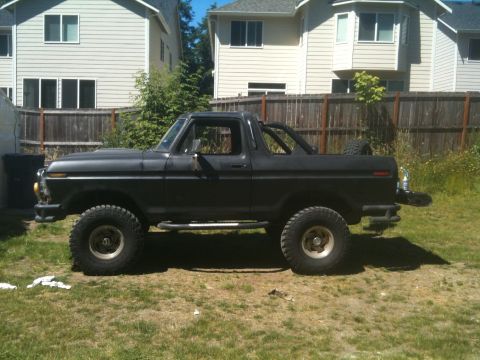 1979 Ford Bronco - This black Ford Bronco is parked in a residential backyard on a sunny day.