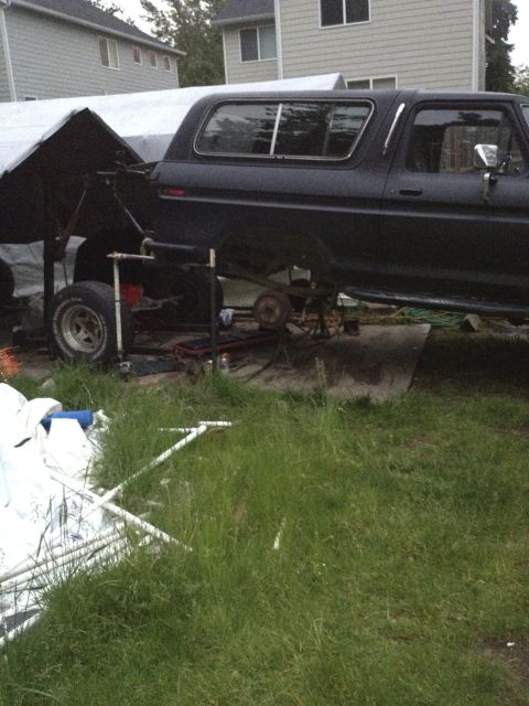 1979 Ford Bronco - This black Ford Bronco is undergoing repairs with its rear axle disassembled and removed.