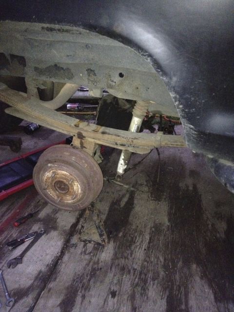 1979 Ford Bronco - Close-up view of the rear suspension and drum brake assembly, indicating a vehicle is being worked on.