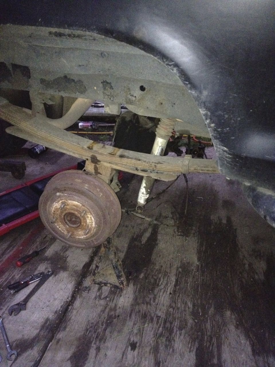 Rear leaf spring suspension and drum brake assembly on a vehicle undergoing repair