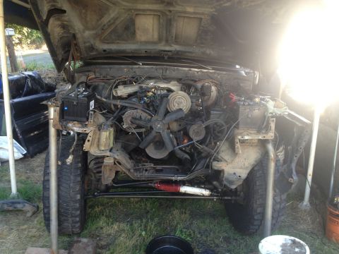1979 Ford Bronco - The engine bay of a 1978 Ford Bronco is exposed, with the hood up and front end partially disassembled.