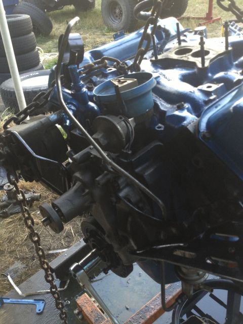 1979 Ford Bronco - Engine block assembly being worked on, suspended by chains.
