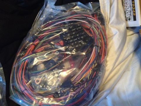 1979 Ford Bronco - New wiring harness in plastic packaging, showing numerous colored wires and connectors.