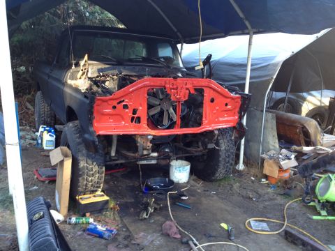 1979 Ford Bronco - A black Ford Bronco is undergoing repairs with its front end removed and engine exposed.