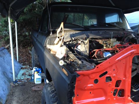 1979 Ford Bronco - Ford truck engine bay undergoing repairs, showing exposed engine and removed front fender.