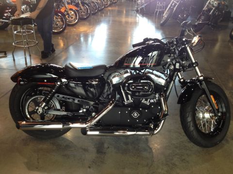 1979 Ford Bronco - A black Harley-Davidson motorcycle is displayed indoors, with other motorcycles in the background.