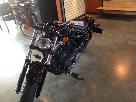1979 Ford Bronco - Black motorcycle parked indoors on a concrete floor.