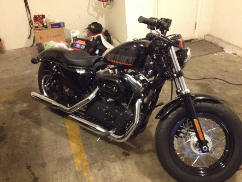 1979 Ford Bronco - A black motorcycle, possibly a Harley-Davidson Forty-Eight, is parked indoors.