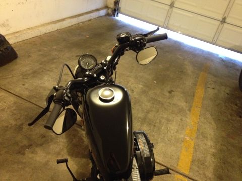 1979 Ford Bronco - A black motorcycle is parked in a garage with a yellow line on the floor.
