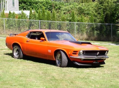 1979 Ford Bronco - This orange 1970 Ford Mustang Boss 429 is shown from the front three-quarter angle on a grassy lawn.