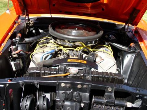 1979 Ford Bronco - Engine bay of an orange car, yellow spark plug wires and a prominent air cleaner.