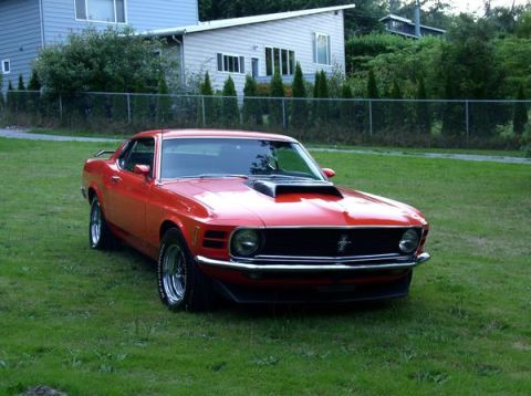 1979 Ford Bronco - 1970 Ford Mustang Mach 1 with a hood scoop sits on a grassy lawn in front of a house.