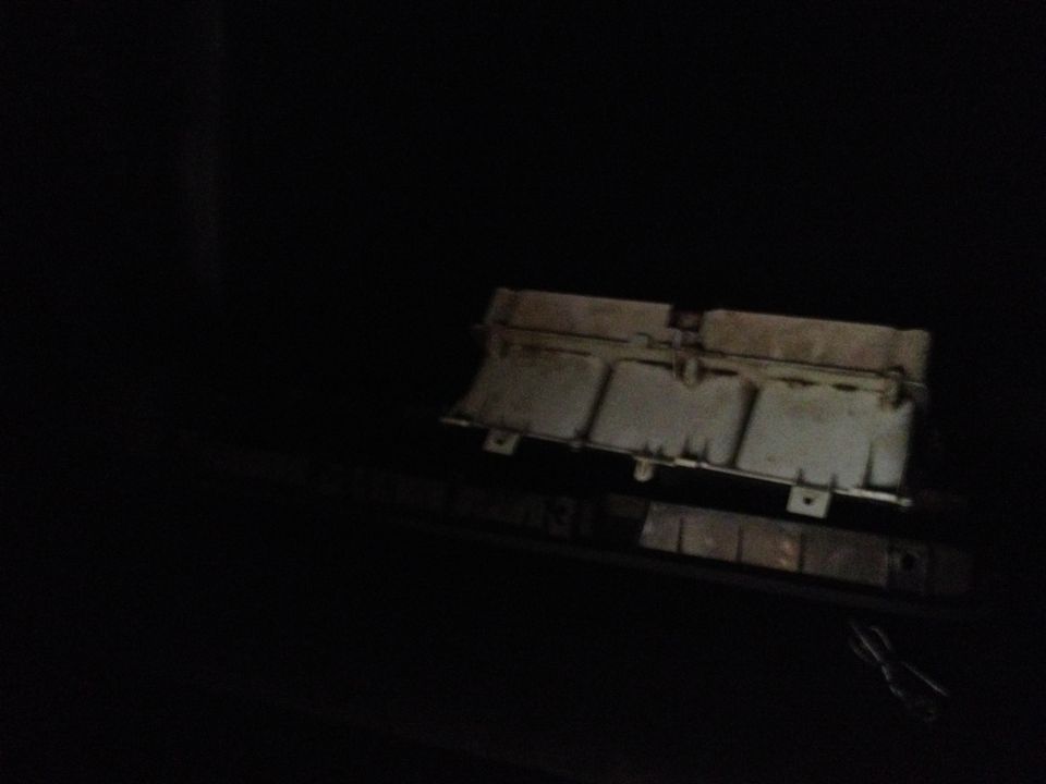 Engine part, possibly an air cleaner housing, in dark lighting