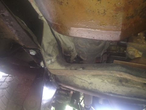 1979 Ford Bronco - Close-up of the underbody structure and suspension parts of a vehicle.