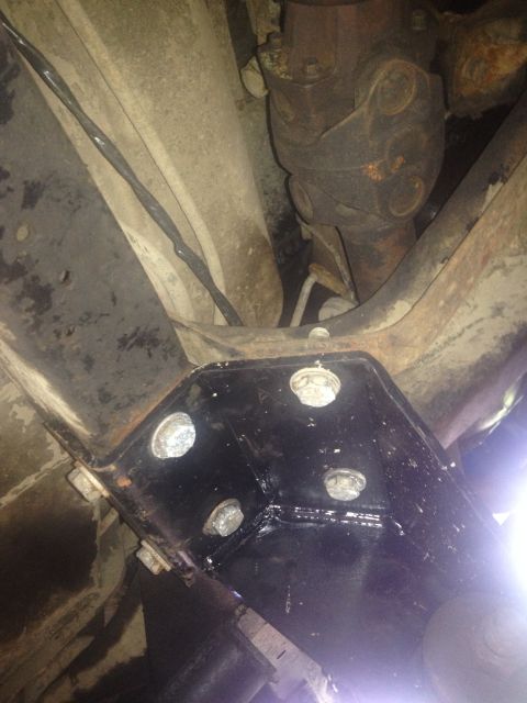 1979 Ford Bronco - Close-up of vehicle undercarriage, focusing on a newly installed black bracket and driveshaft components.