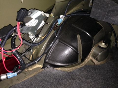 2002 Ford Mustang - Close-up view of aftermarket wiring and a black plastic component, possibly related to a ProCharger system, installed in a vehicle's trunk…