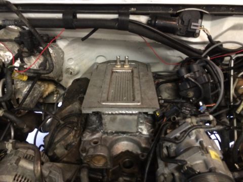 1996 Ford Bronco - Close-up view of a supercharger installed in a vehicle's engine bay, showing intricate wiring and components.