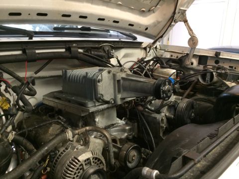 1996 Ford Bronco - Close-up view of a vehicle's engine compartment, highlighting a supercharger installation.