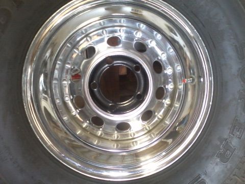 1978 Ford Bronco - Close-up of a chrome wheel and tire, the Supermotors.net logo in the lower right corner.