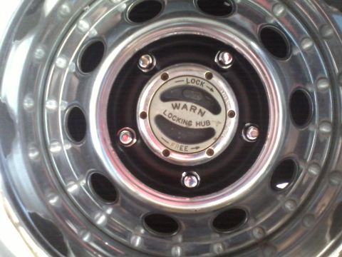 1978 Ford Bronco - A chrome wheel a Warn locking hub, indicating it's part of a 4x4 system.