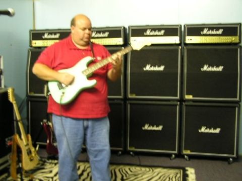 1994 Ford Bronco - A man plays an electric guitar in a room filled with Marshall amplifiers and two other guitars visible.