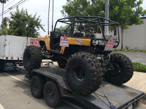 1968 Ford Mustang - A heavily modified off-road vehicle is loaded onto a trailer, ready for transport.