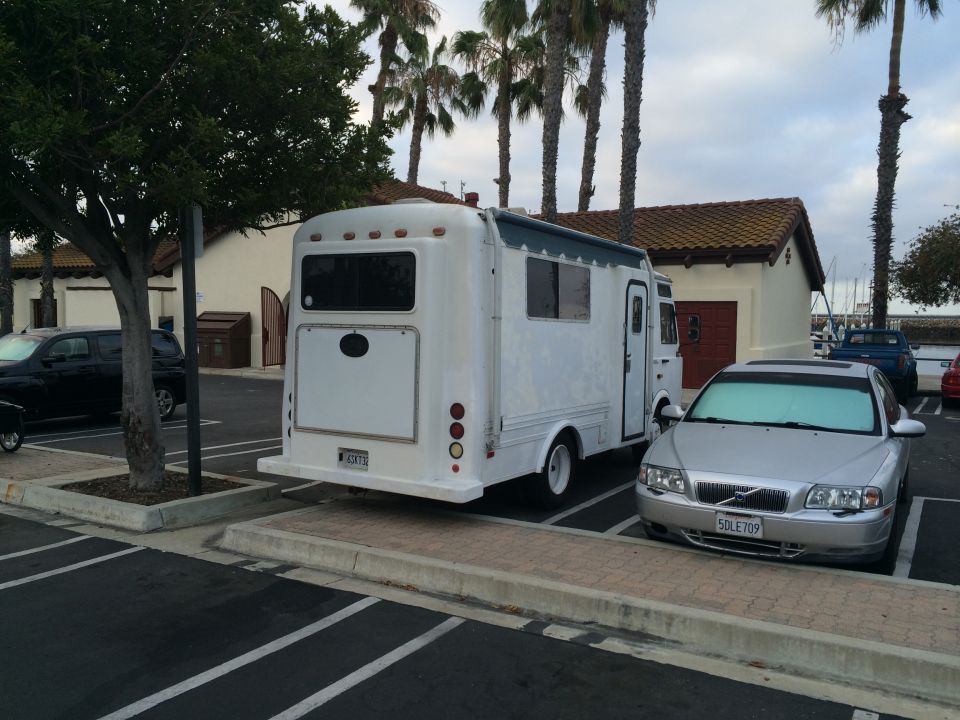 White RV parked next to a silver Volvo sedan
