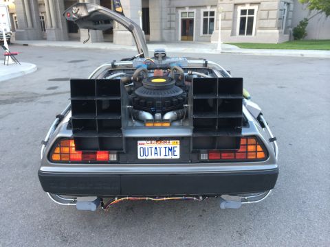 1968 Ford Mustang - The iconic DeLorean time machine, modified with external vents and a distinctive license plate, is shown from the rear.