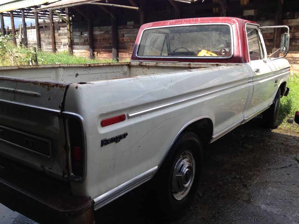 White and maroon Ford pickup truck, side view. It has a 'Ranger' badge on the fender