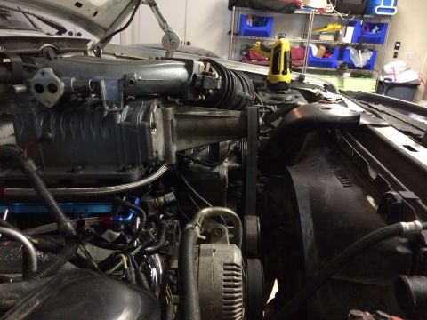 1996 Ford Bronco - Close-up view of a vehicle's engine bay, highlighting a supercharger installation.