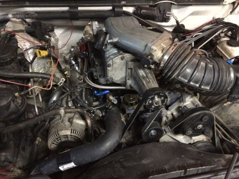1996 Ford Bronco - Close-up view of a vehicle's engine bay, highlighting a supercharger and associated components.