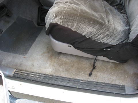 1994 Ford Bronco - Close-up of a vehicle's passenger seat and floor area, showing wear and tear.
