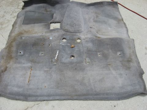 1994 Ford Bronco - This is a removed section of gray car carpet, showing mounting holes and wear.