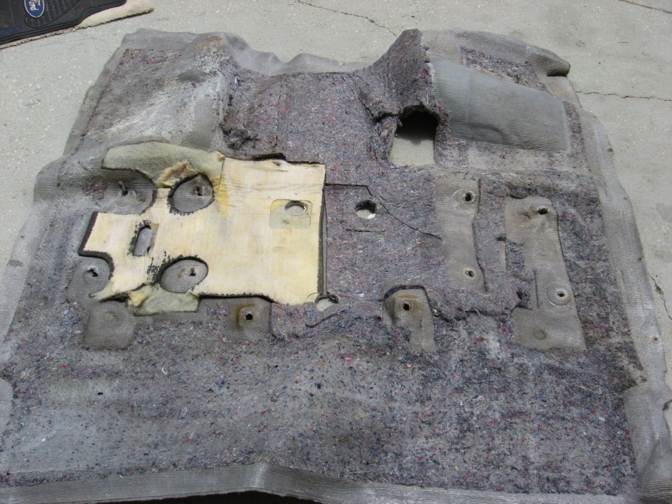 removed car carpet padding with metal mounting brackets