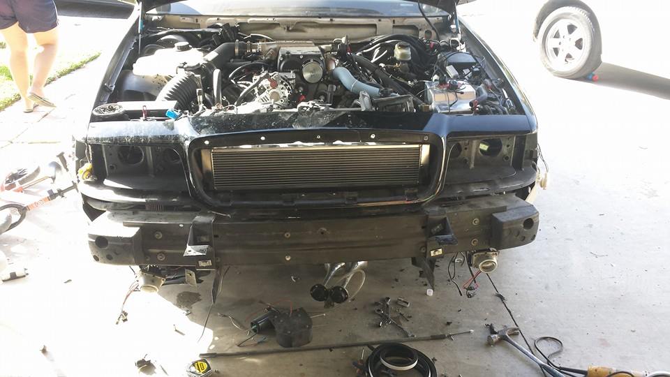 Car with front end disassembled showing intercooler in driveway