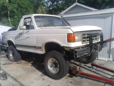 1988 Ford Bronco - how its sitting currently. with no weight in the front, its quite abit higher than it should be. also the rear tires are completely flat. a…