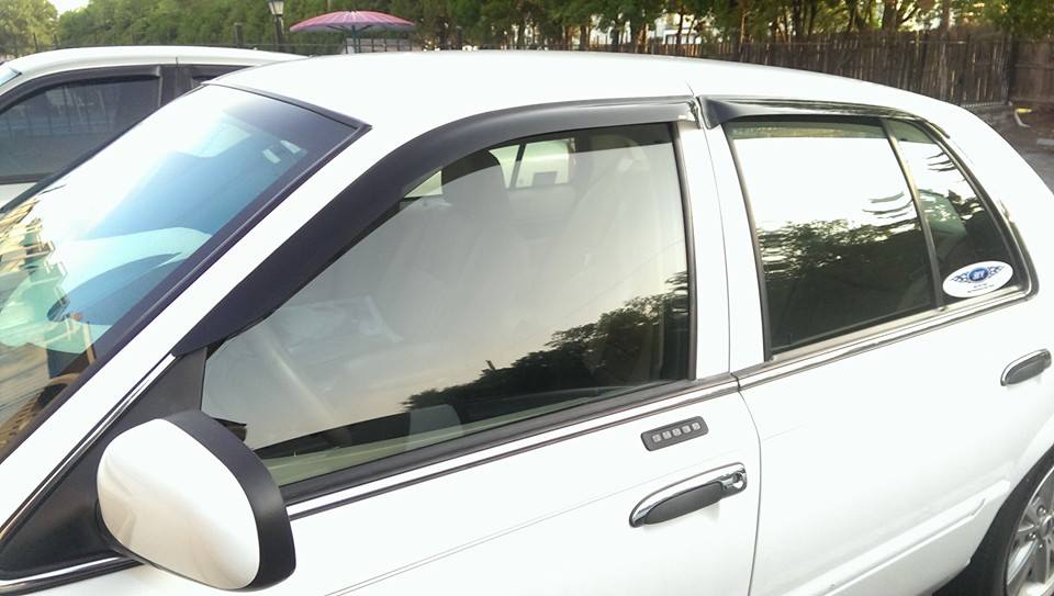 Side view of a white 2000 Mercury Grand Marquis with a keypad on the door