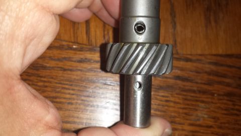 1984 Ford Bronco - A close-up shows a metal gear with helical teeth mounted on a shaft.
