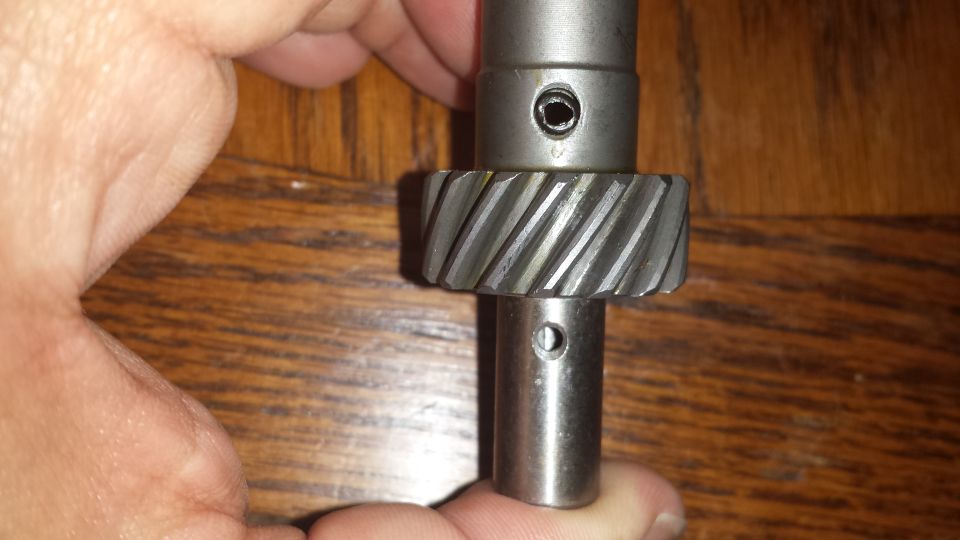 metal gear on a shaft, held by a hand