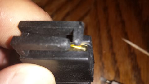 1984 Ford Bronco - Close-up of a black plastic electrical connector showing its gold-plated contacts.