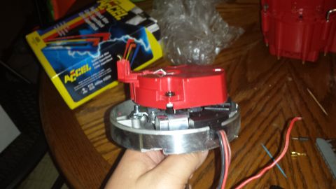 1984 Ford Bronco - A person holds a red distributor cap and rotor, with a box of ACCEL spark plug wires visible in the background.